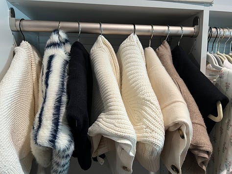 Jeans and sweaters hanging in my closet.