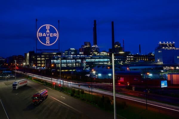 A large industrial facility with the Bayer logo at night. 