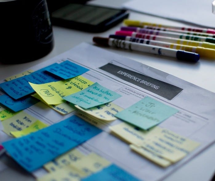 sticky notes on paper document beside pens and box sticky notes on paper document beside pens and box