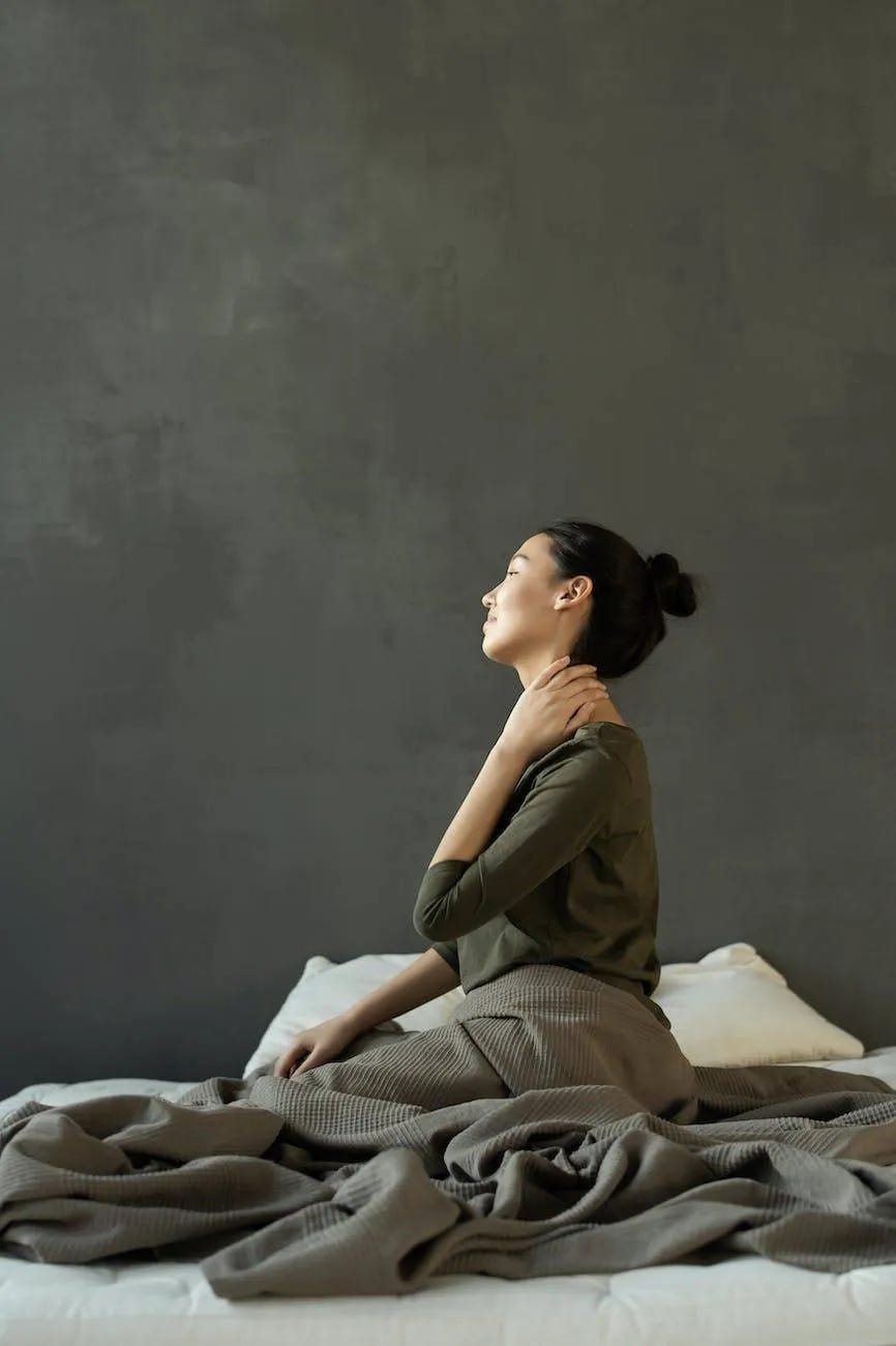 woman in gray dress sitting on bed woman in gray dress sitting on bed