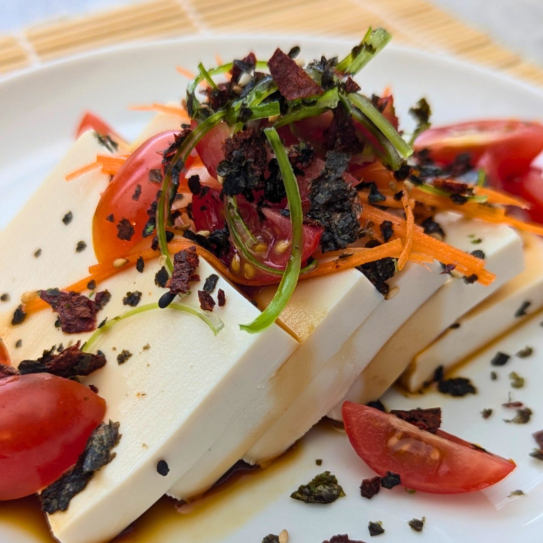 Silken tofu topped with cherry tomatoes, shredded carrots, scallions, ponzu, and tomato furikake.