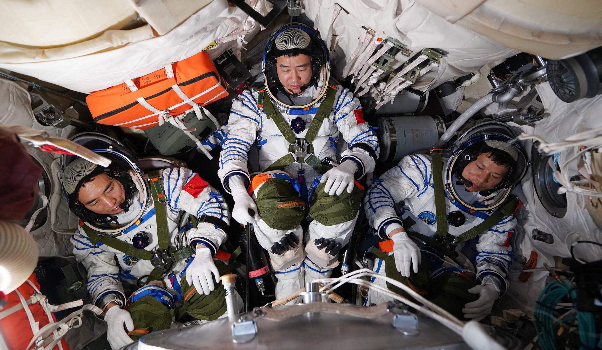 Chen Zhongrui (left), Chen Dong (center), and Wang Jie (right) inside the Shenzhou-20 spacecraft during a pre-launch rehearsal.