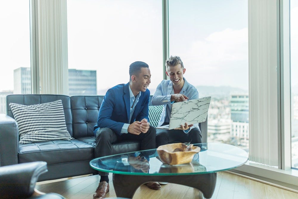 two men in suit sitting on sofa two men in suit sitting on sofa