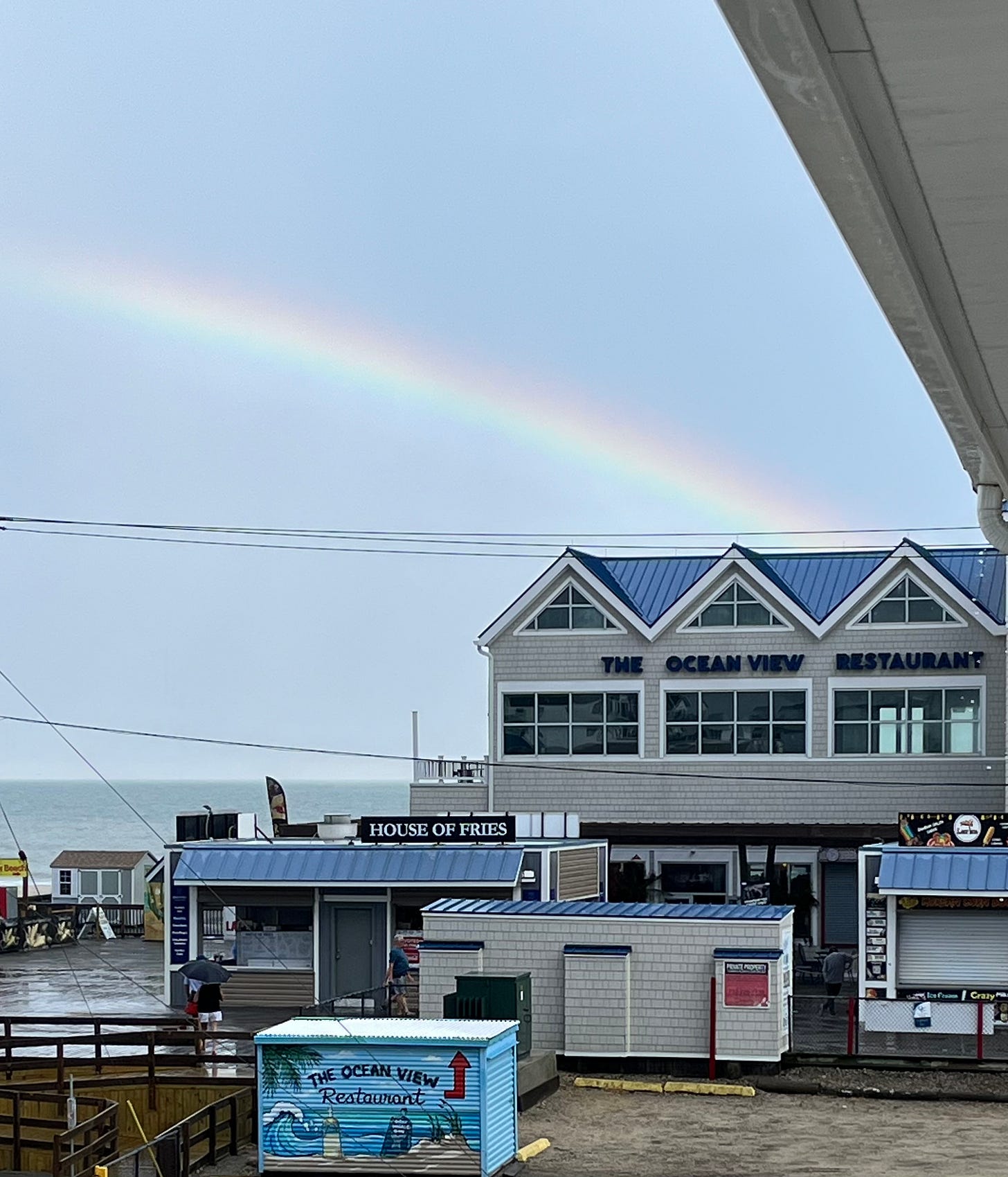 A rainbow with the Ocean View Restaurant and House of Fries in the foreground.