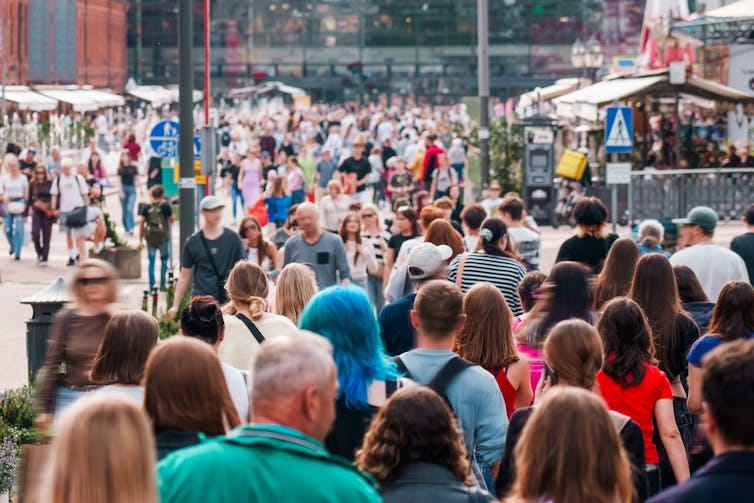 Crowd of people milling around a downtown area