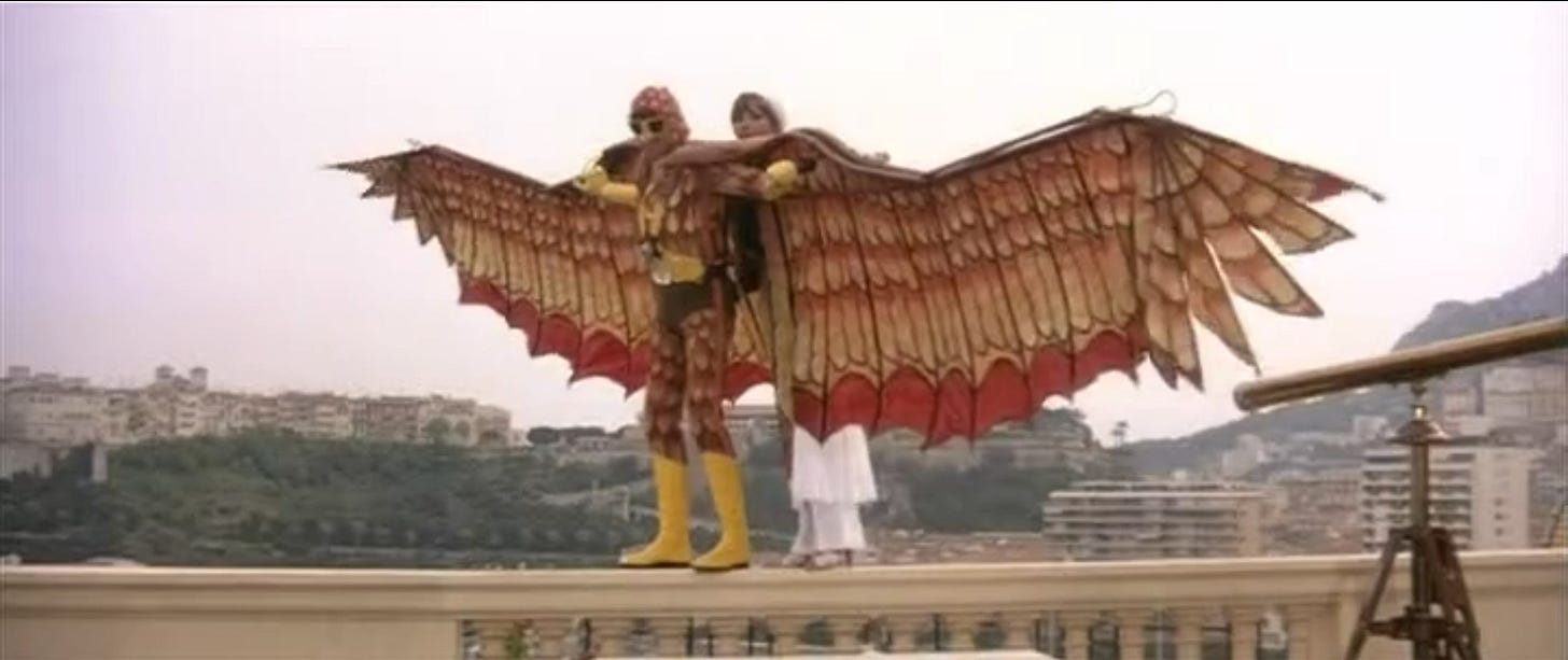 Woody in his Condorman costume, about to whisk Natalia away.