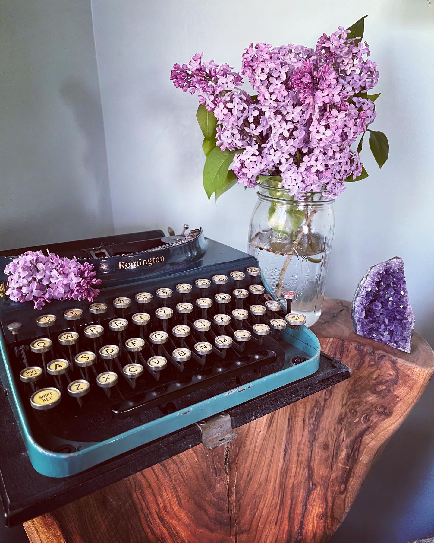 typewriter with lilac blossoms and amethyst crystal