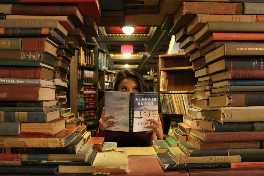 woman surrounded by books woman surrounded by books