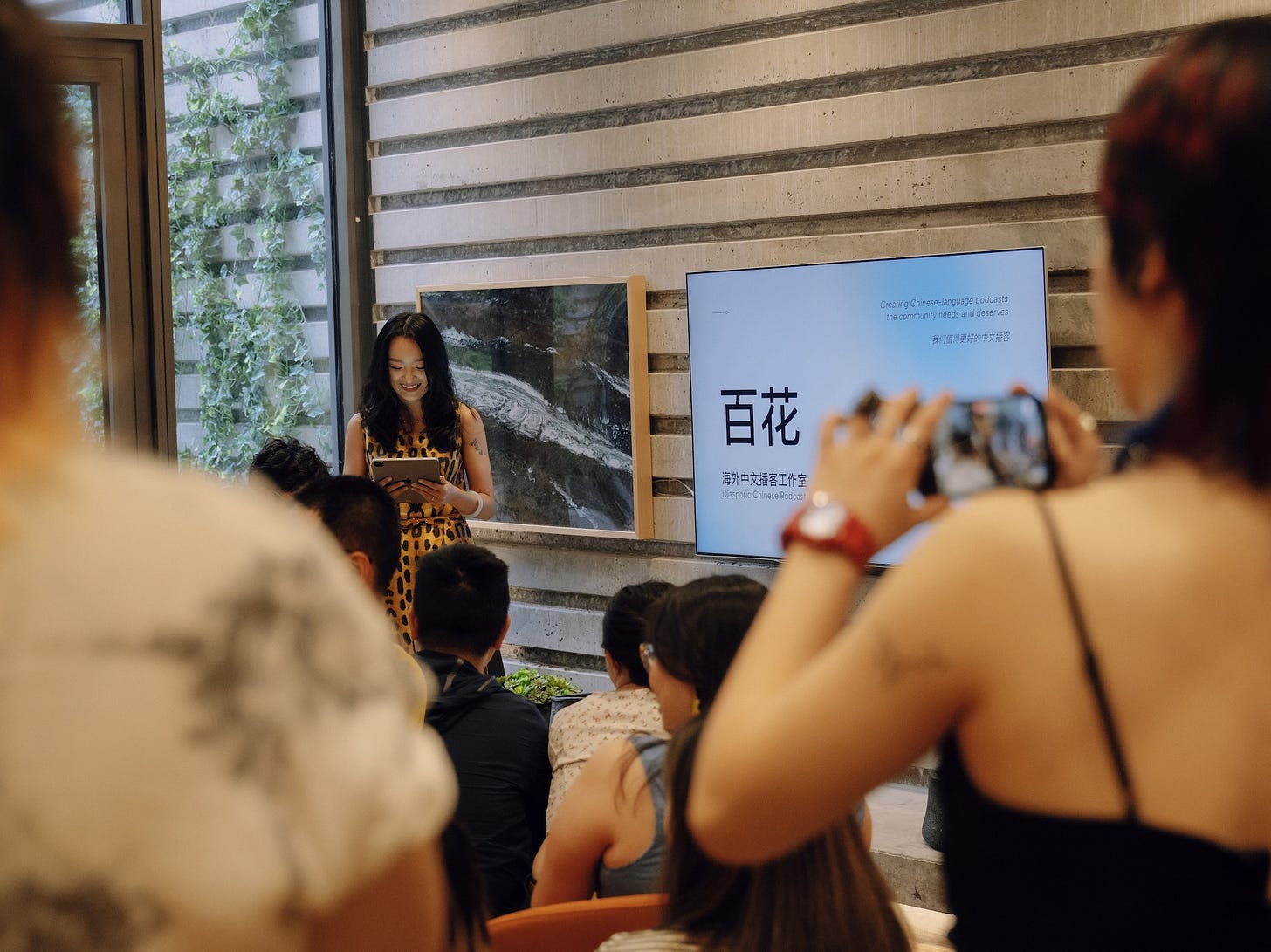 A woman presenting slides about Baihua at a gathering A woman presenting slides about Baihua at a gathering