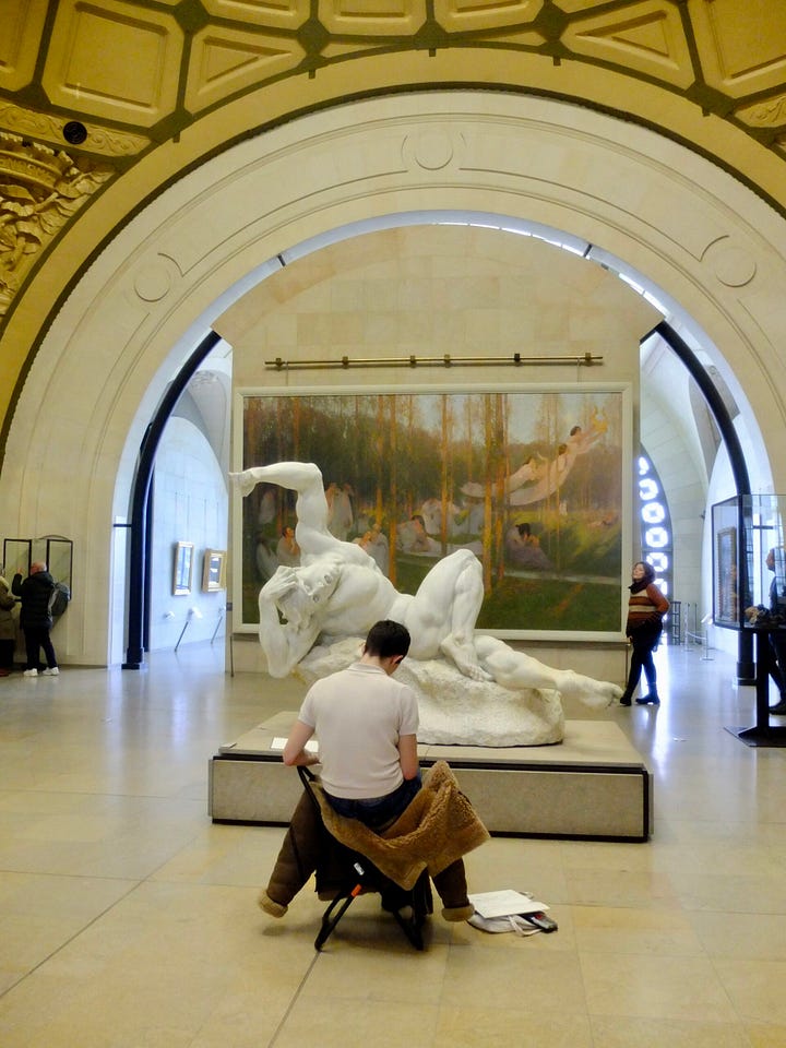 inside musee d'orsay and artist drawing a sculpture