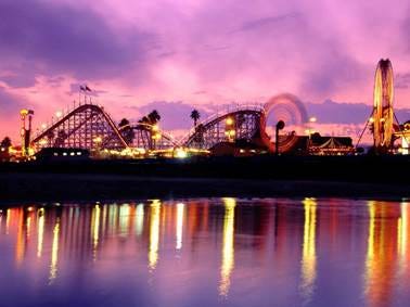 A roller coaster at night with a purple sky

AI-generated content may be incorrect.