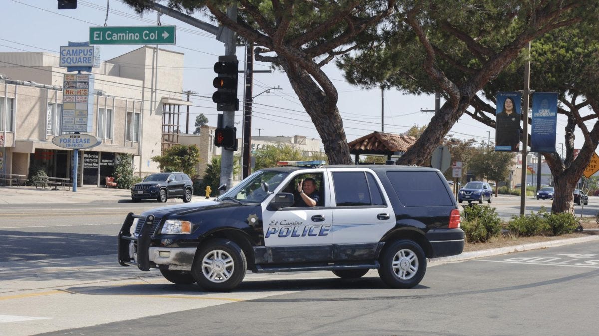 Sgt. Ruben Lopez waves while driving a campus police car before completing a turn onto Crenshaw Boulevard on Monday, Oct. 6. (Madison Moody | The Union)