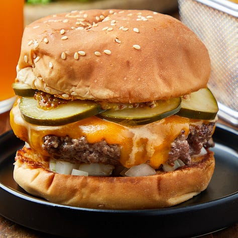 burgers on a grill, burger patty topped with cheese, assembled burger