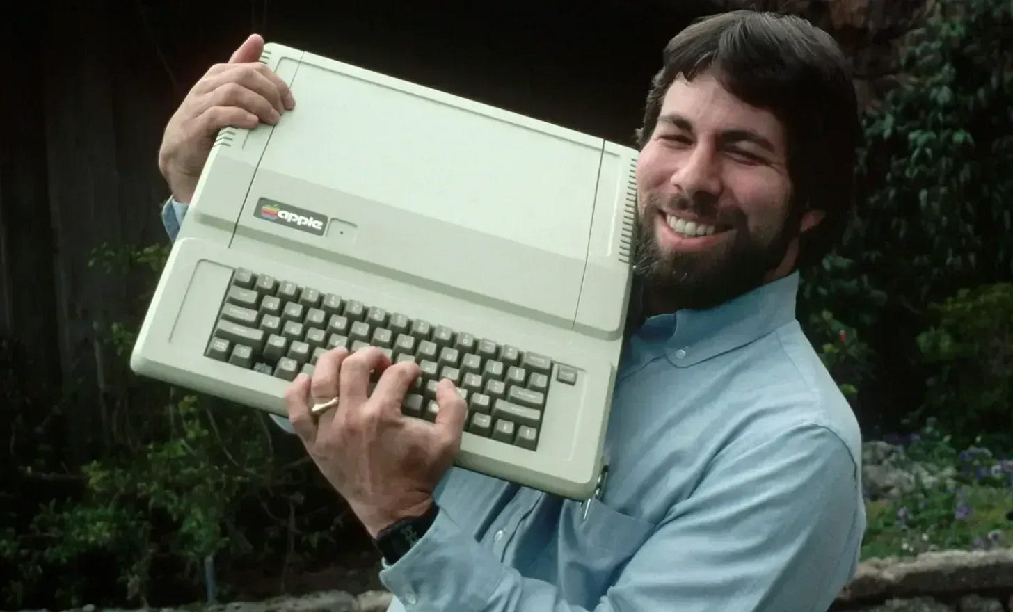 Un hombre sosteniendo un modelo viejo de computadora. Un hombre sosteniendo un modelo viejo de computadora.