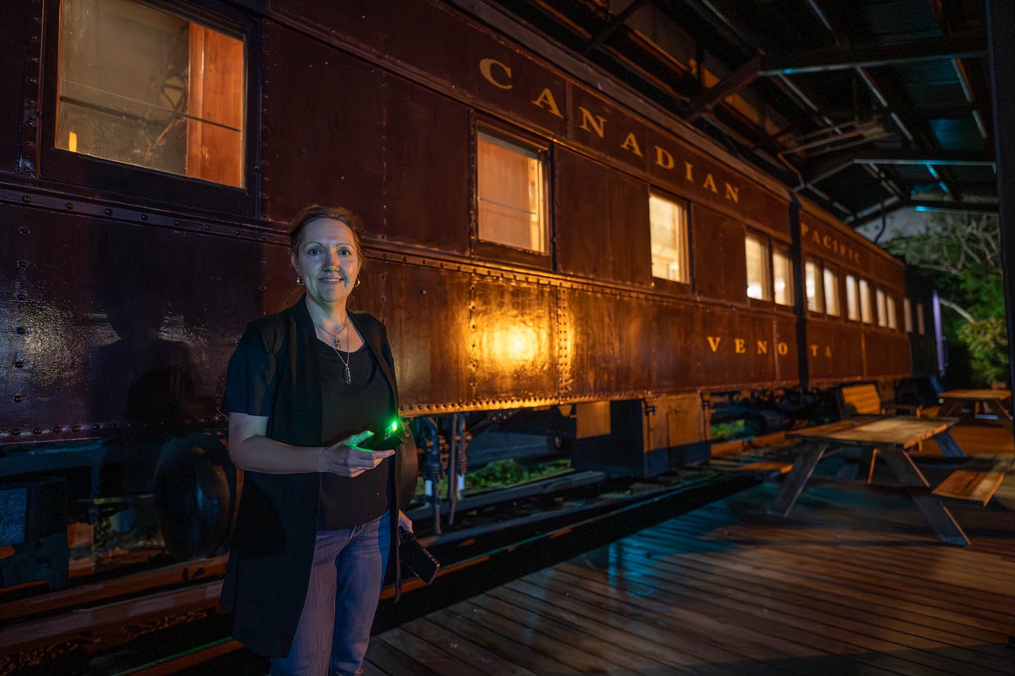 Victoria Vancek stands outside the historic Venosta passenger train car at the PoMo Museum during a ghost investigation on Aug 16, 2025. Photo by BW Homer
