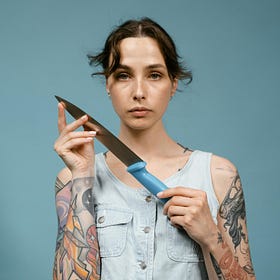 Woman holds the knife on the sharp side