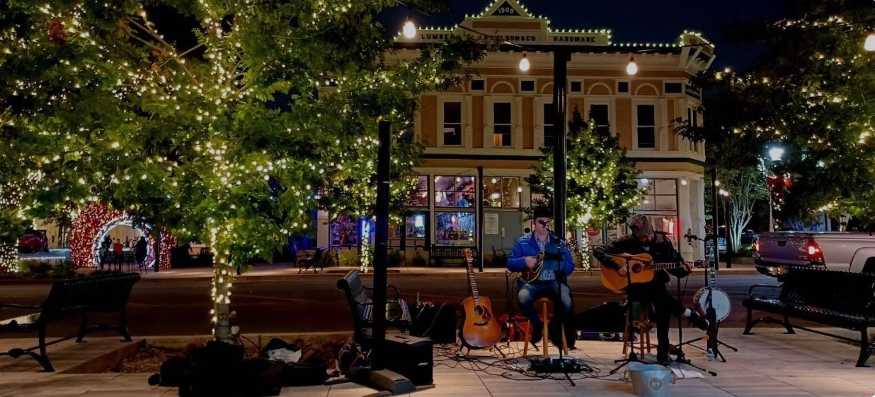 musicians play during the holidays in a parquet festooned with lights musicians play during the holidays in a parquet festooned with lights