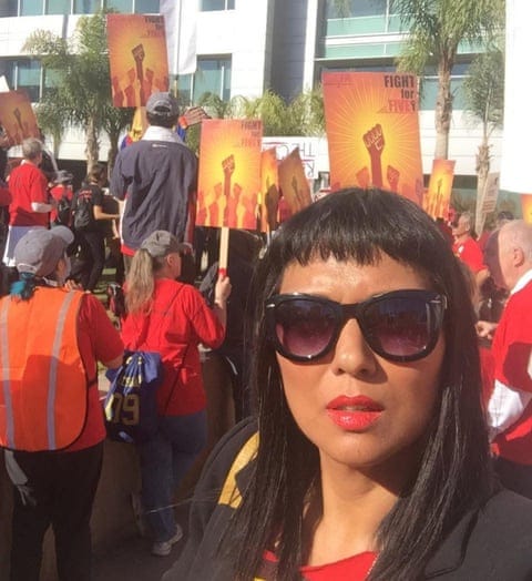a women in front of people holding signs 