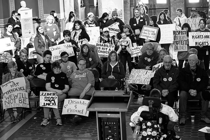 A gallery of black and white photos of a rally in the rotunda of Montana's state capitol. people are holding signs in support of disability rights, there is a podium with legislators speaking, people with a virety of physical disabilities are throughout the crowd.