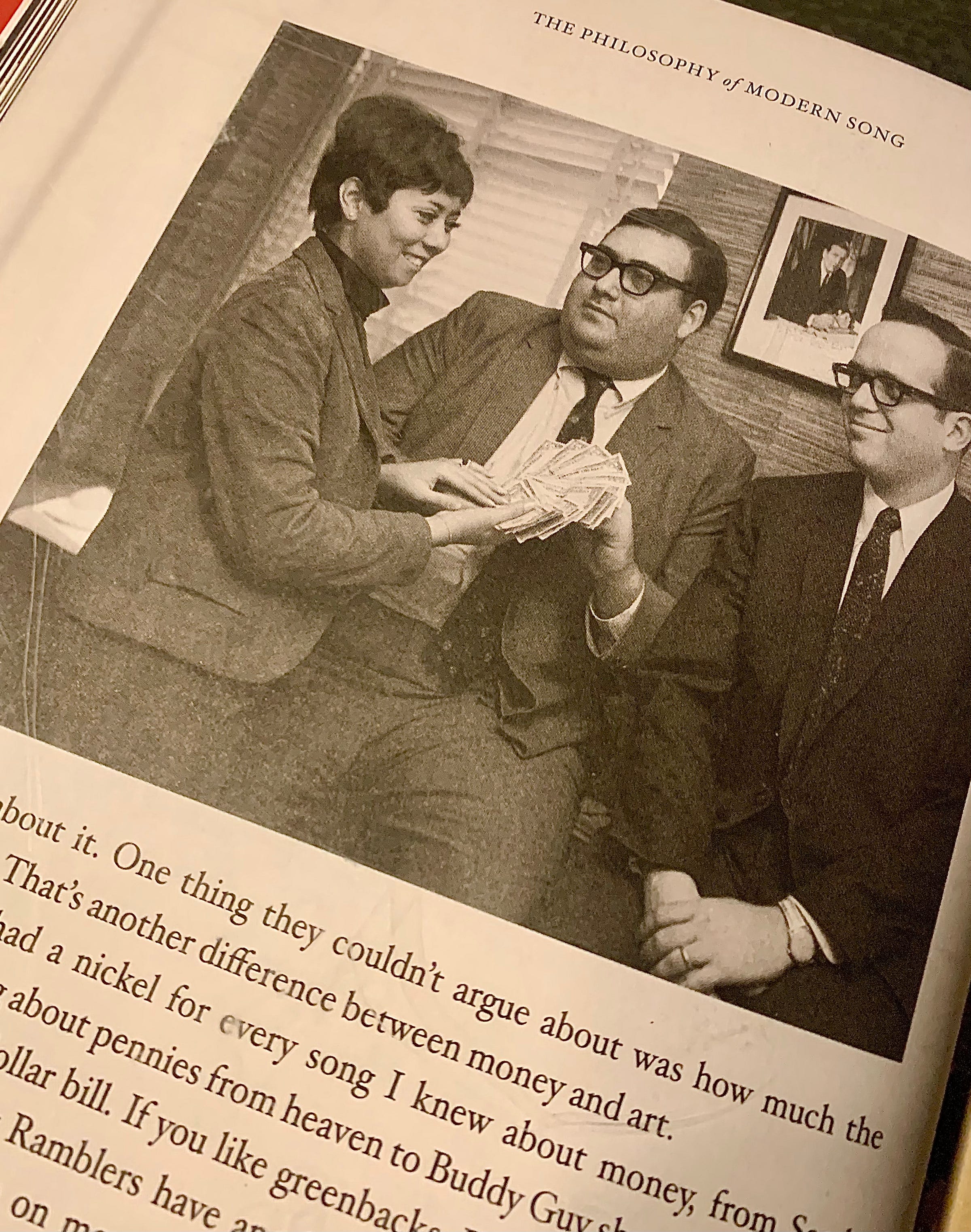 Photo of three office workers posing with cash