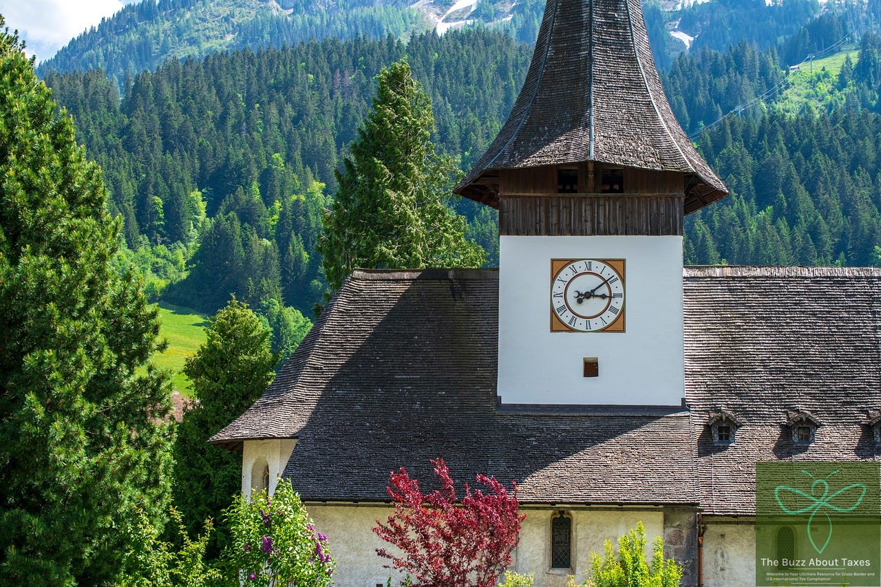 A clock tower with Mountains in the back in Swiss town of Berne. 