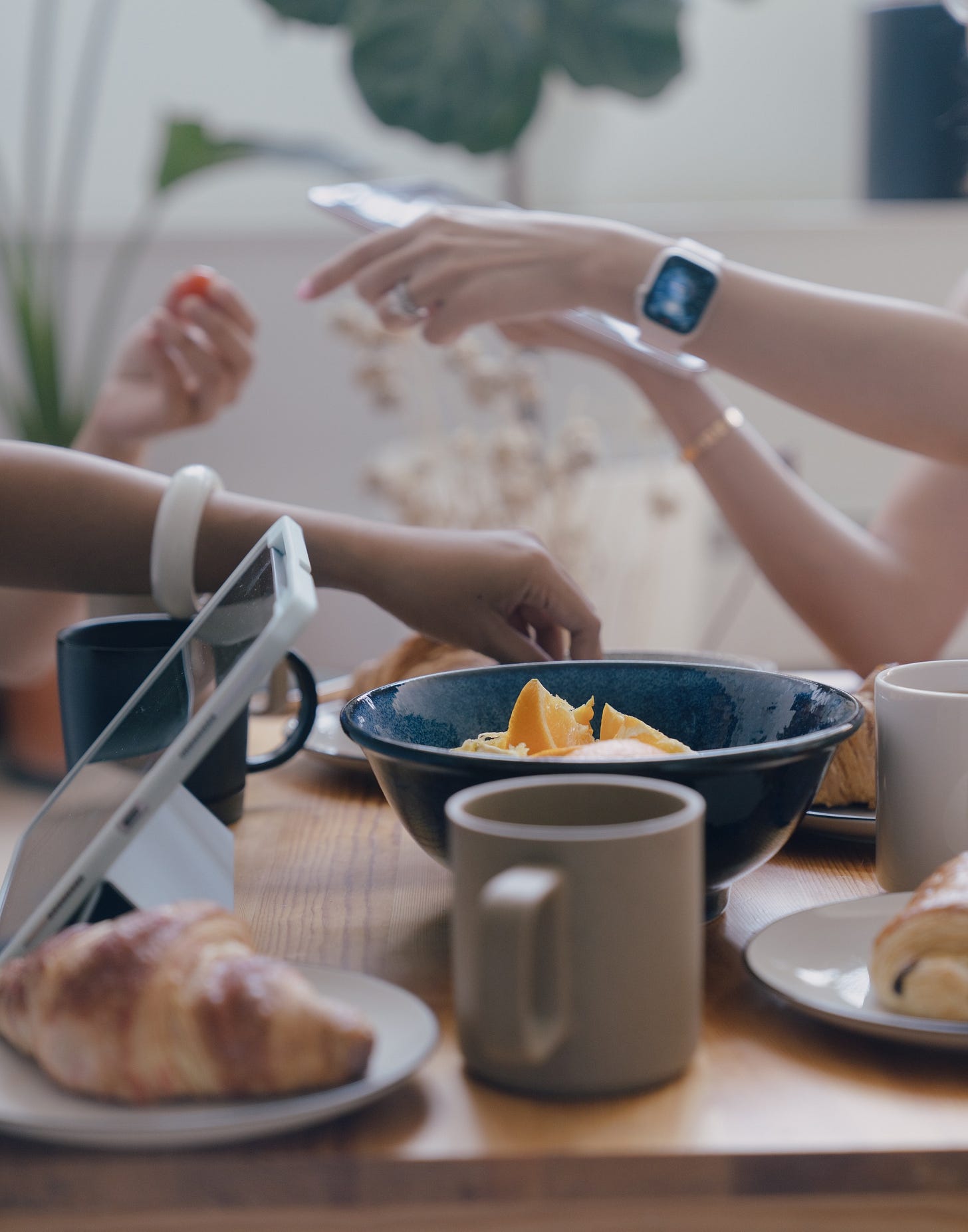 four women sitting around a table, only their hands are visible, seemingly engaged in conversation four women sitting around a table, only their hands are visible, seemingly engaged in conversation