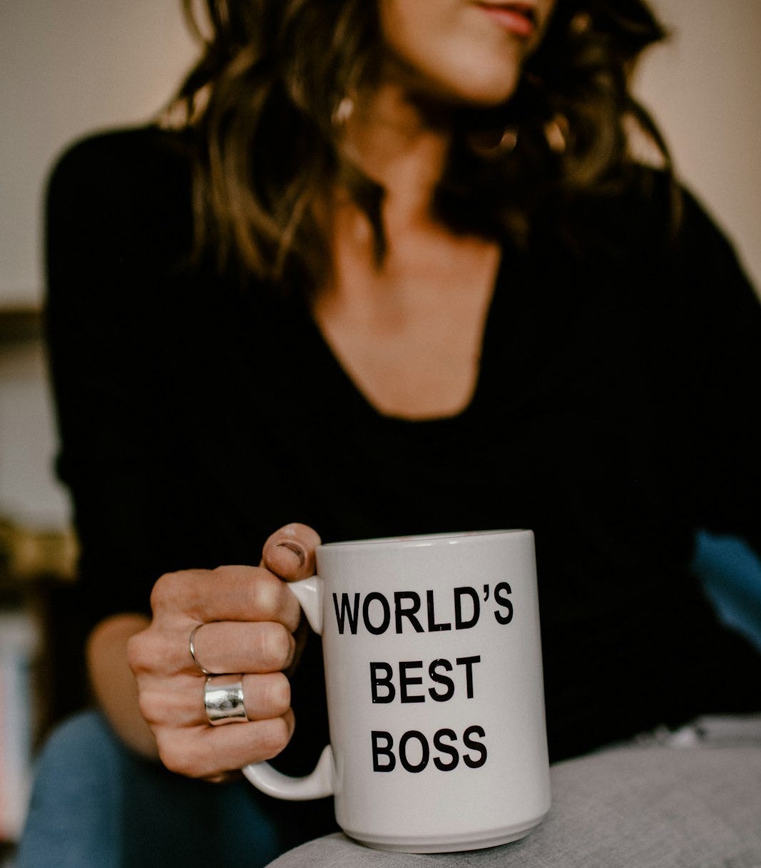 woman in black v neck shirt holding white ceramic mug