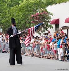 A person in tall black clothes holding a flag

AI-generated content may be incorrect.