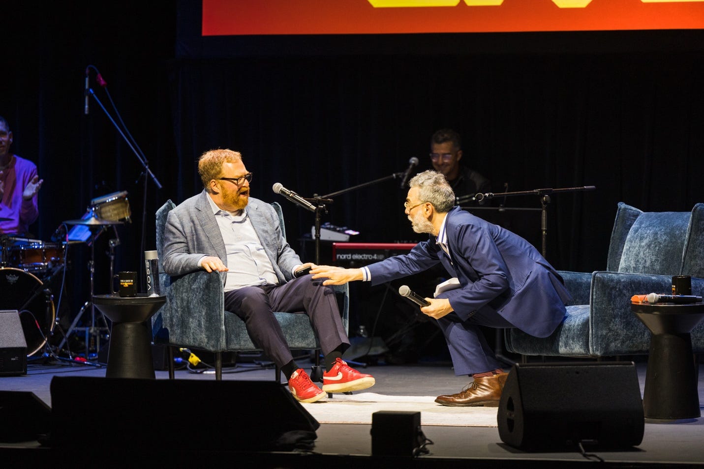 Two men sitting on a stage
Description automatically generated Two men sitting on a stage
Description automatically generated