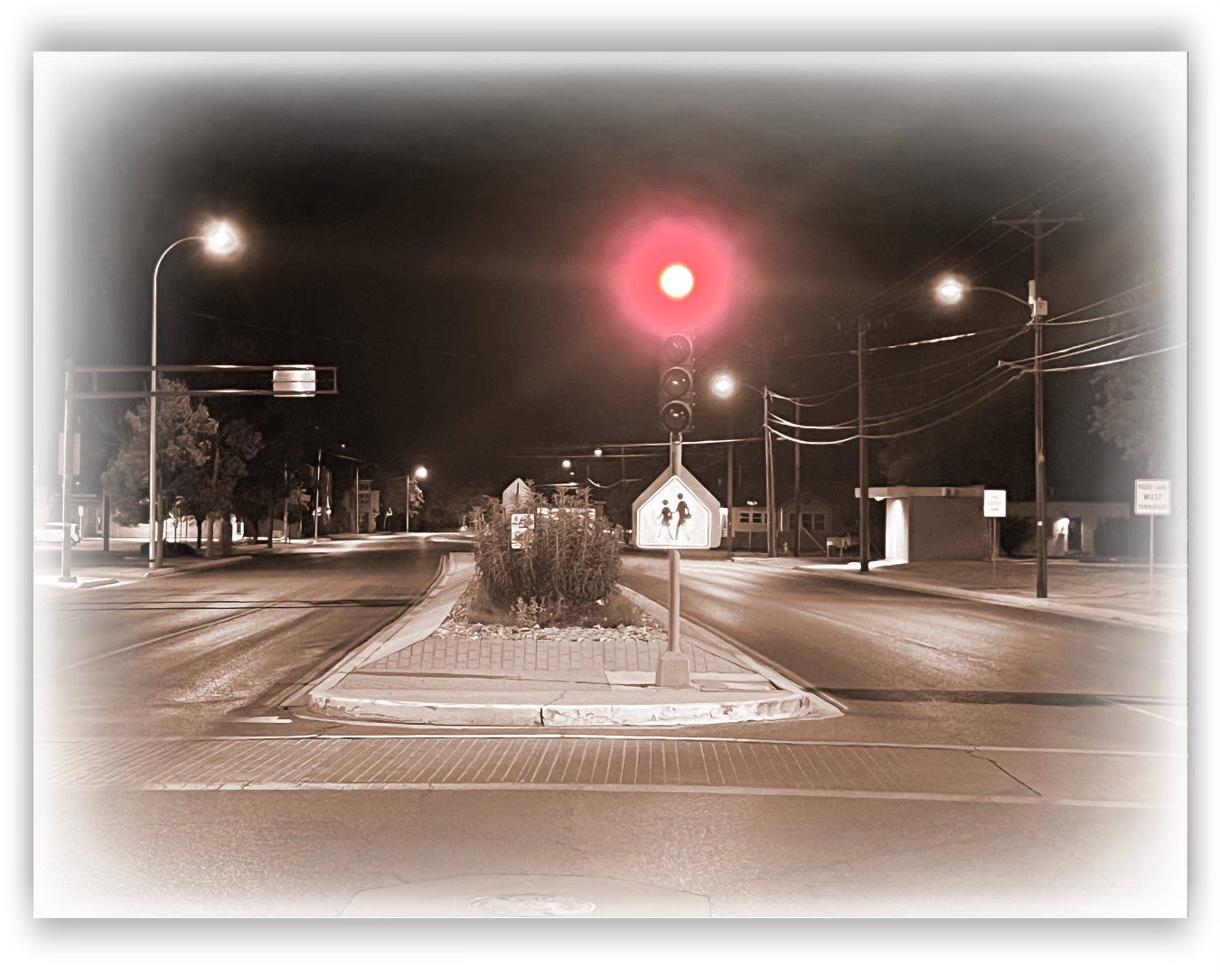 A red traffic light on a wide four-lane road with no traffic.