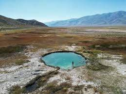 A person standing in a small pond in a desert

AI-generated content may be incorrect.