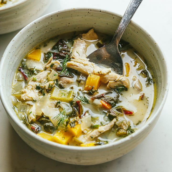 Charred lemon and dill chicken soup in a pot and in a bowl.