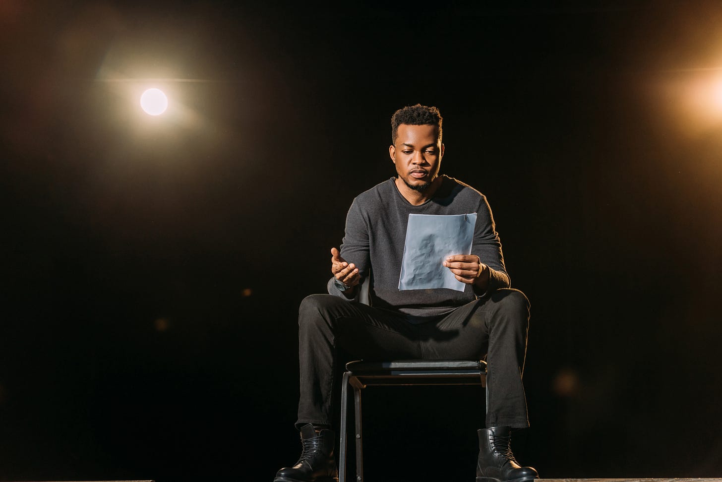 african american actor holding scenario and standing on stage during rehearse in theatre