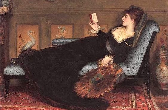 A woman reclining on a couch and reading A woman reclining on a couch and reading