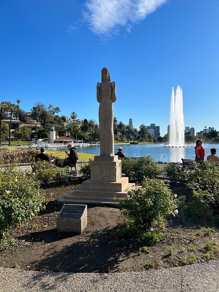 the view of DTLA over the echo park lake fountain and lady of the lake statue