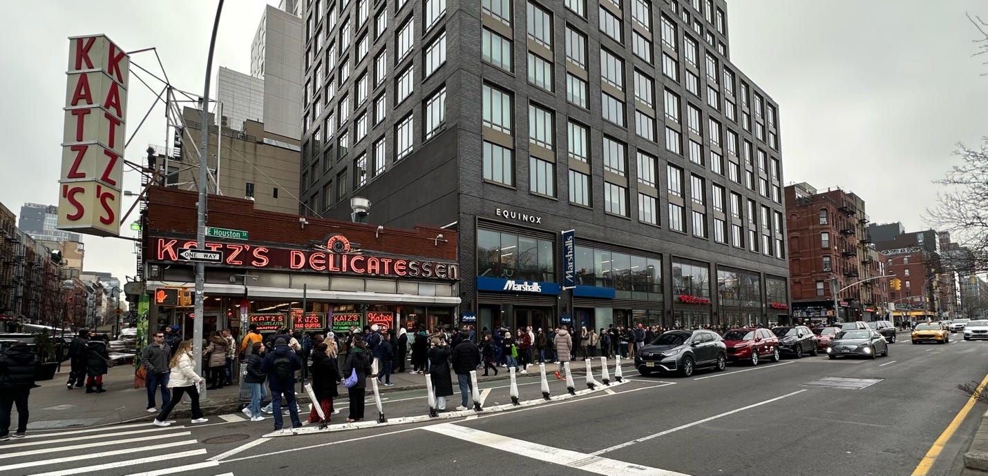 A group of people standing in front of a building

Description automatically generated