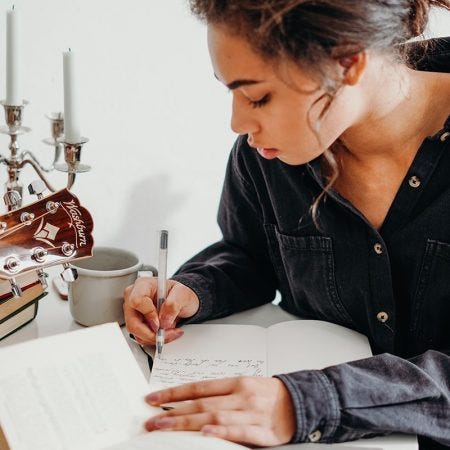 A person writing on a piece of paper

Description automatically generated