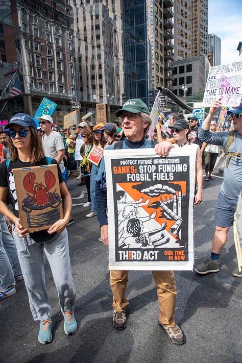 Six photos showing closeups of marchers with various banners and signs
