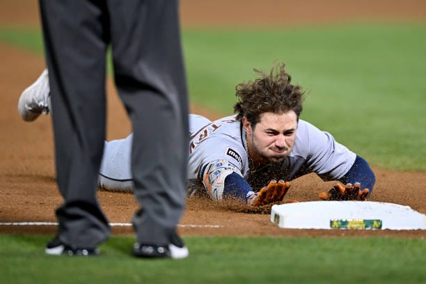 Zach McKinstry of the Detroit Tigers slides into third base on a throwing error on his double against the Oakland Athletics in the fifth inning at...
