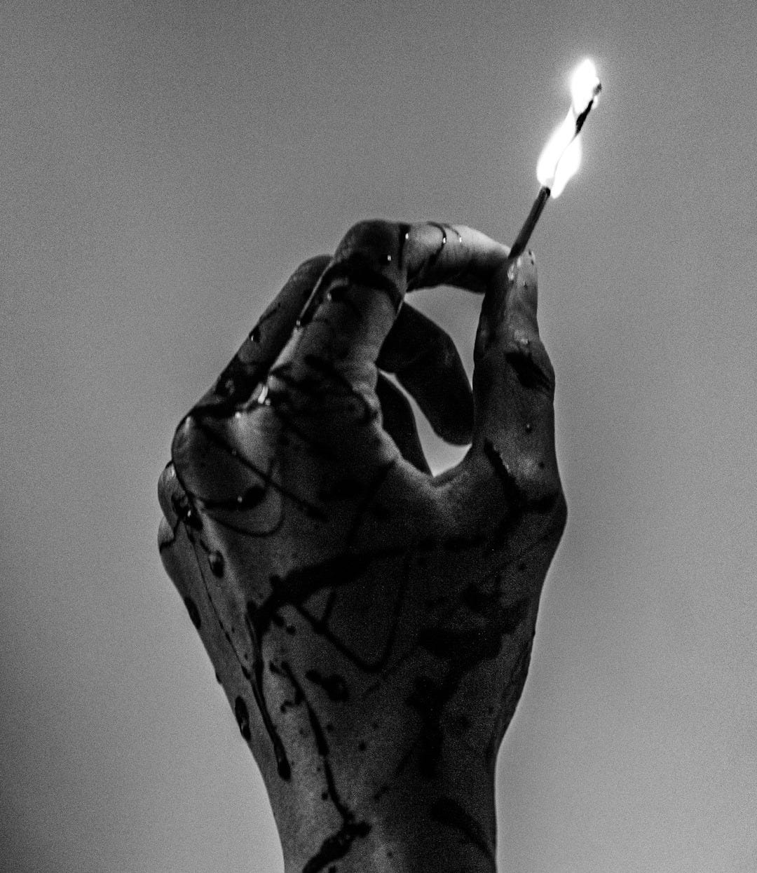 grayscale photo of person holding lighted match stick