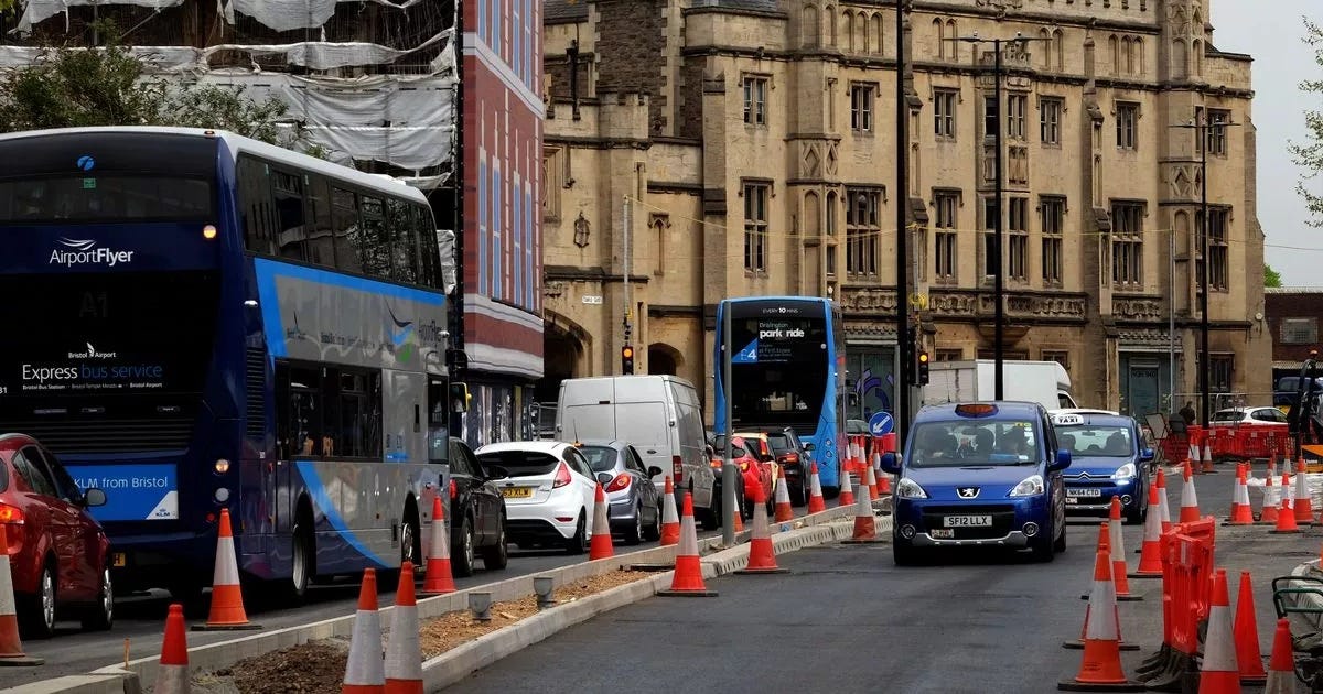 Perfect image choice - this is exactly what your article needs. Here's the Substack setup: Alt Text: "Traffic congestion at Temple Gate, Bristol, showing multiple lanes of vehicles including buses, taxis, and vans navigating through roadworks marked by traffic cones, with the historic Grosvenor Hotel visible in the background Perfect image choice - this is exactly what your article needs. Here's the Substack setup: Alt Text: "Traffic congestion at Temple Gate, Bristol, showing multiple lanes of vehicles including buses, taxis, and vans navigating through roadworks marked by traffic cones, with the historic Grosvenor Hotel visible in the background