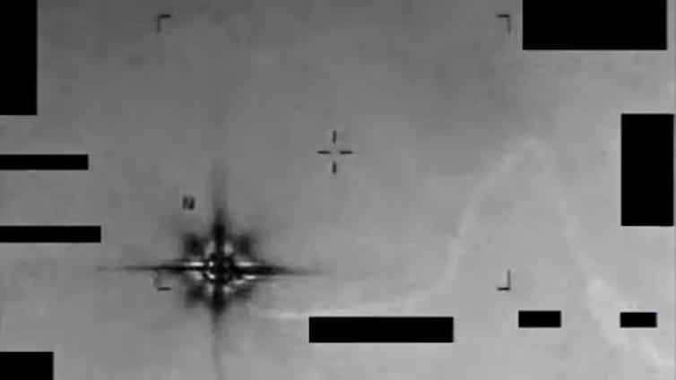 A grainy photo of a dark, blurry object in the sky.