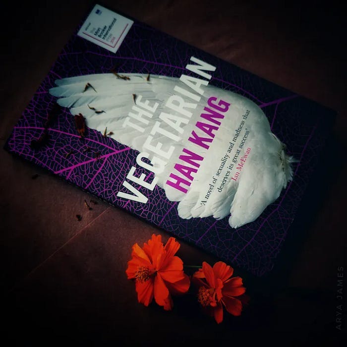 A photo of a cover image of The Vegetraian by Han Kang. It has a single wing of a white hen.