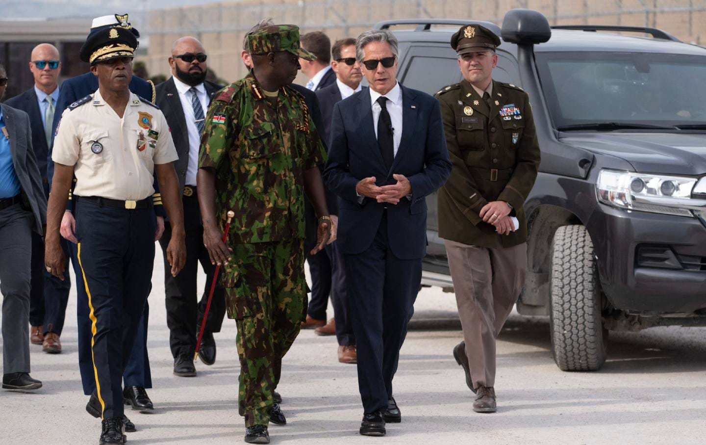 Anthony Blinken walking with a man in a Haitian military uniform Anthony Blinken walking with a man in a Haitian military uniform