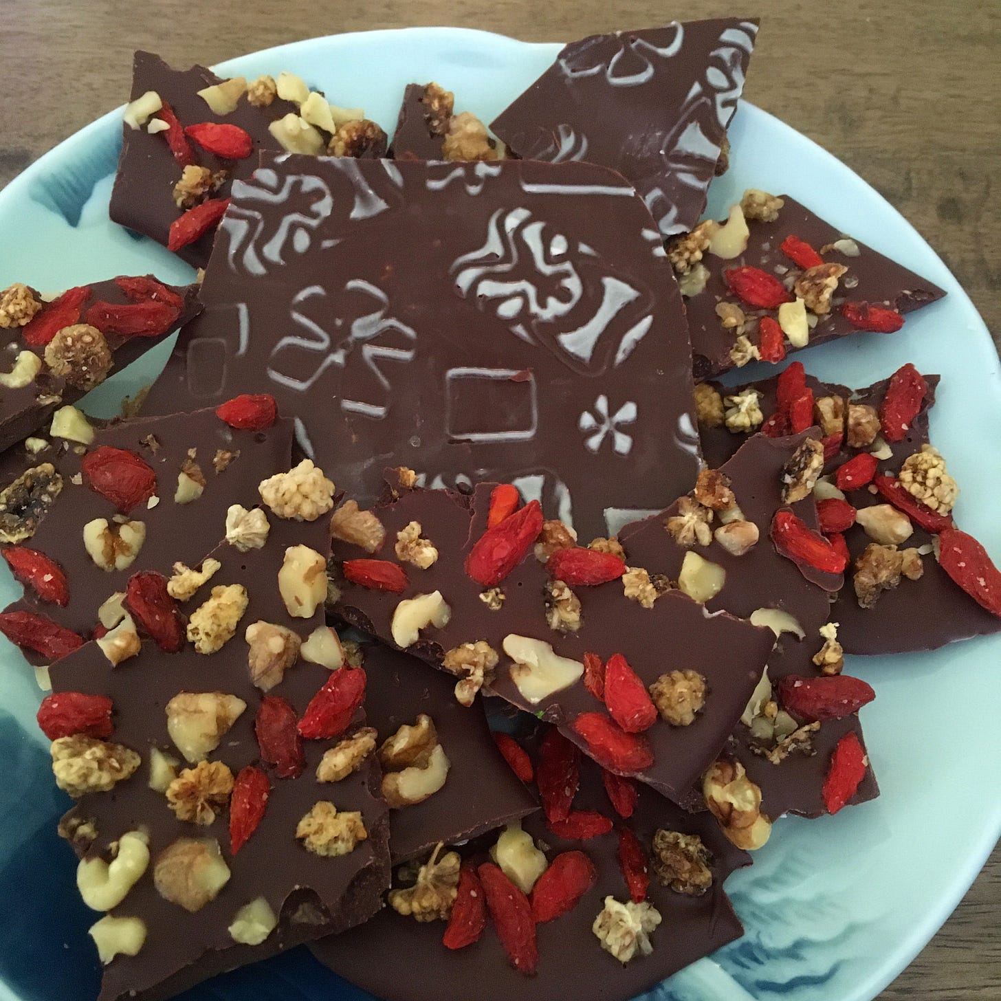 Hawaiian tiki and plumeria pattern on dark chocolate bark with goji, mulberries, and walnuts
