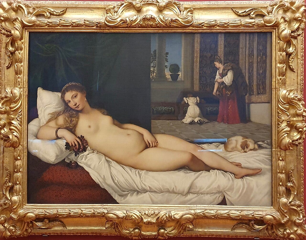 A small spaniel asleep at the foot of a reclining nude