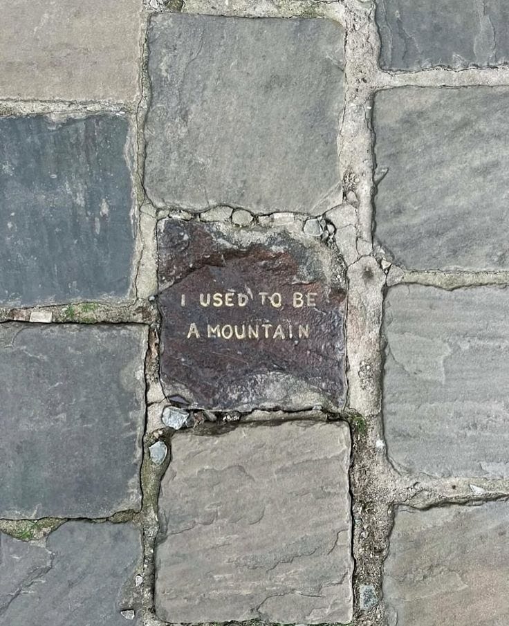 This may contain: a stone wall with writing on it that says i used to be a mountain in