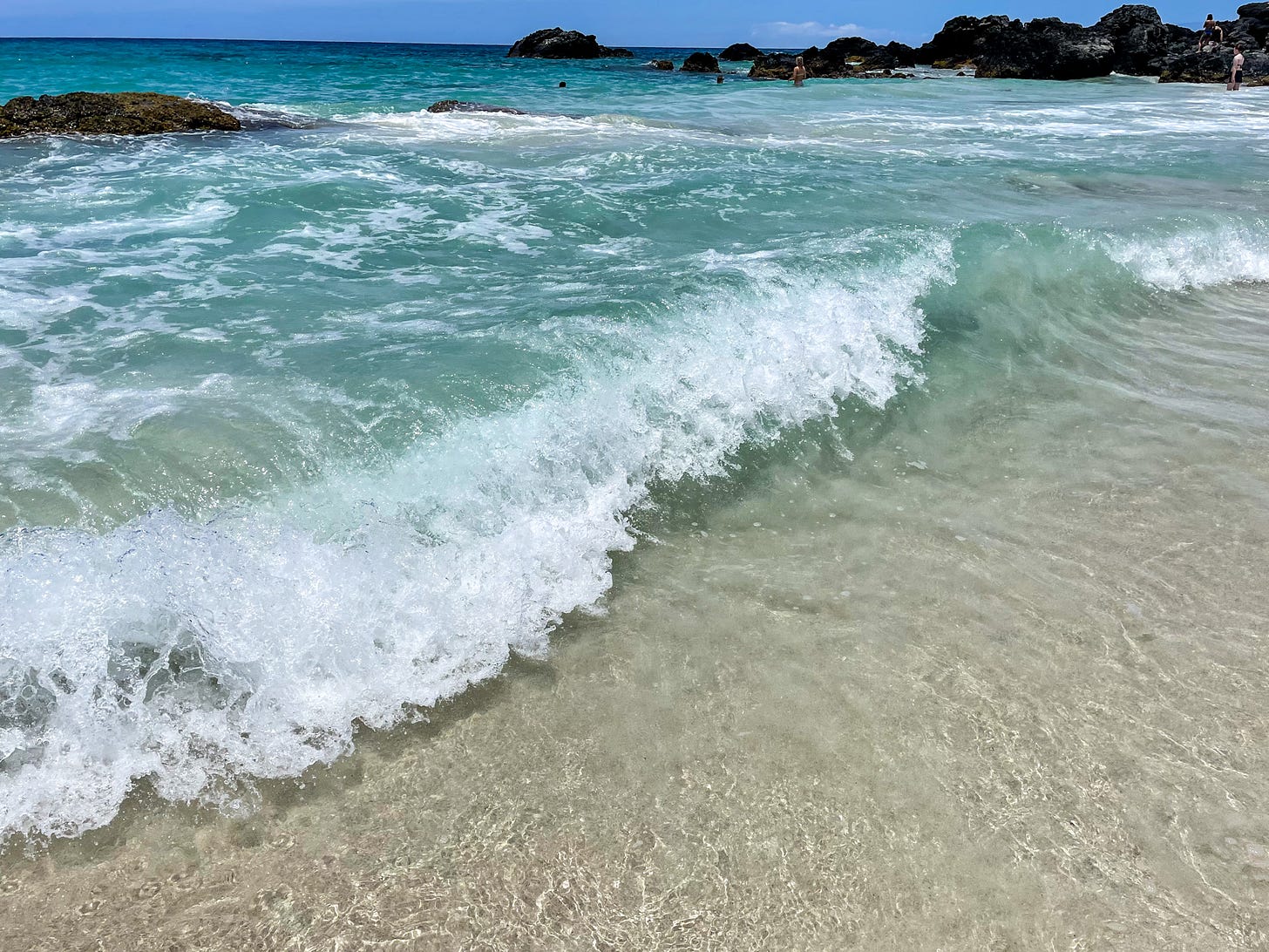 Crystal-clear water, waves, and white sand beach 