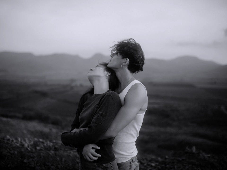 a man and a woman standing in a field