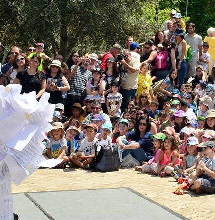 Children and adults around a performance space at an outdoor festival in Israel